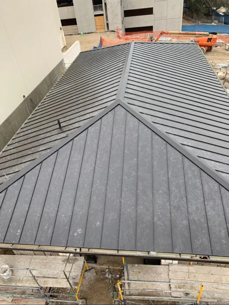 Commercial metal roof construction with crane equipment in Greenfield